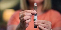 A woman prepares her dose of a weight loss injection using a Semaglutide pen.